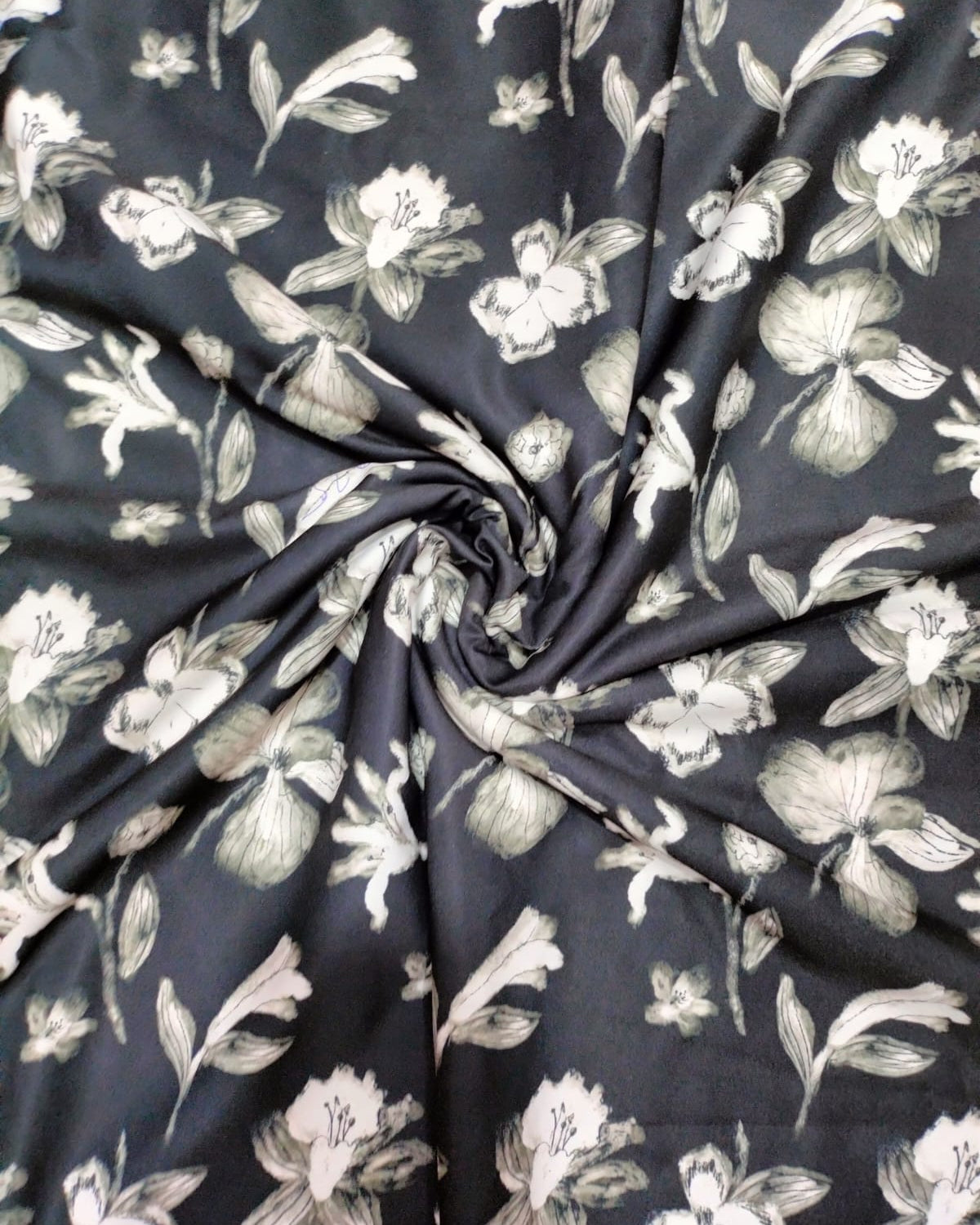 Close detail of the white floral motif on black micro crepe
