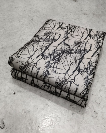 Cream and black branch print moss fabric shown full width