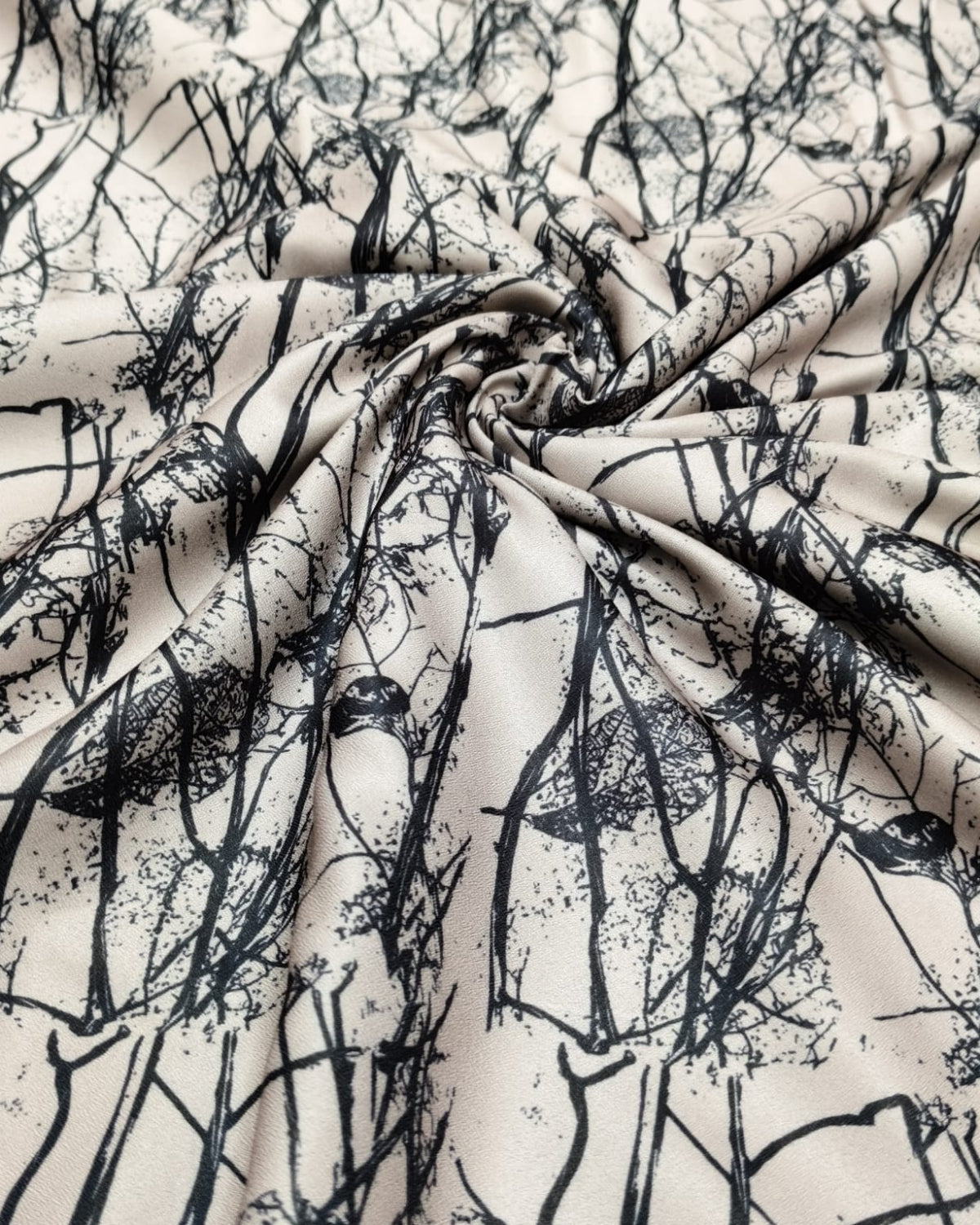 Close detail of the fine black branch motif on cream moss