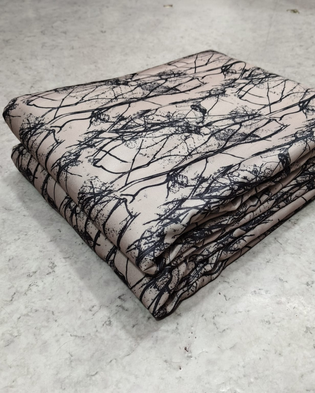 Branch printed moss dress material folded into a cut piece
