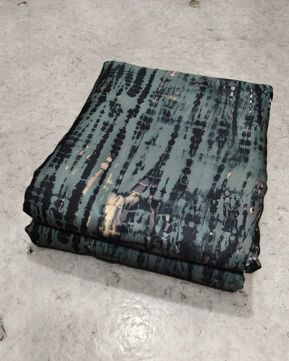 Teal shibori tie dye print moss fabric folded into a cut piece