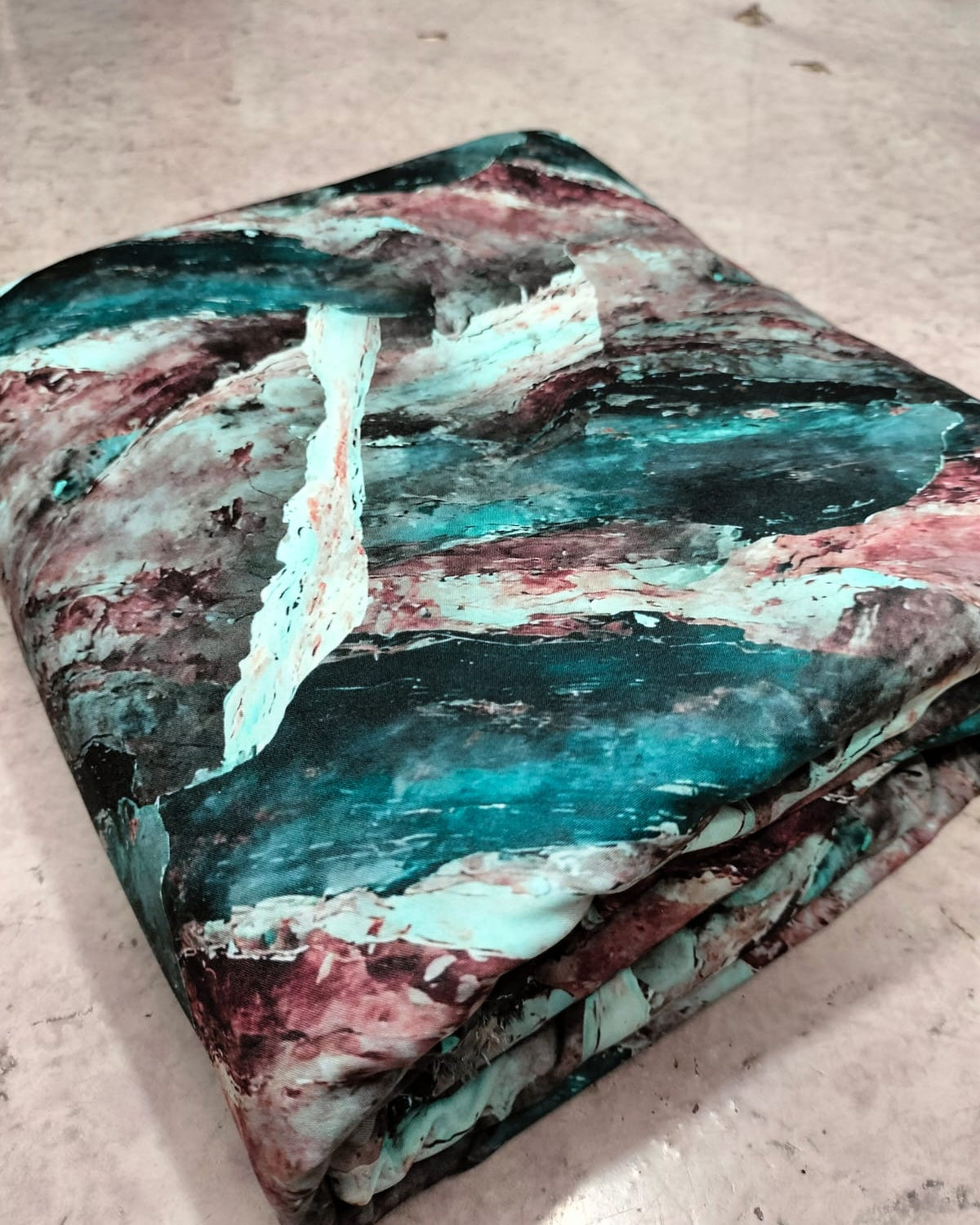 Close detail of the abstract marble print on teal micro crepe