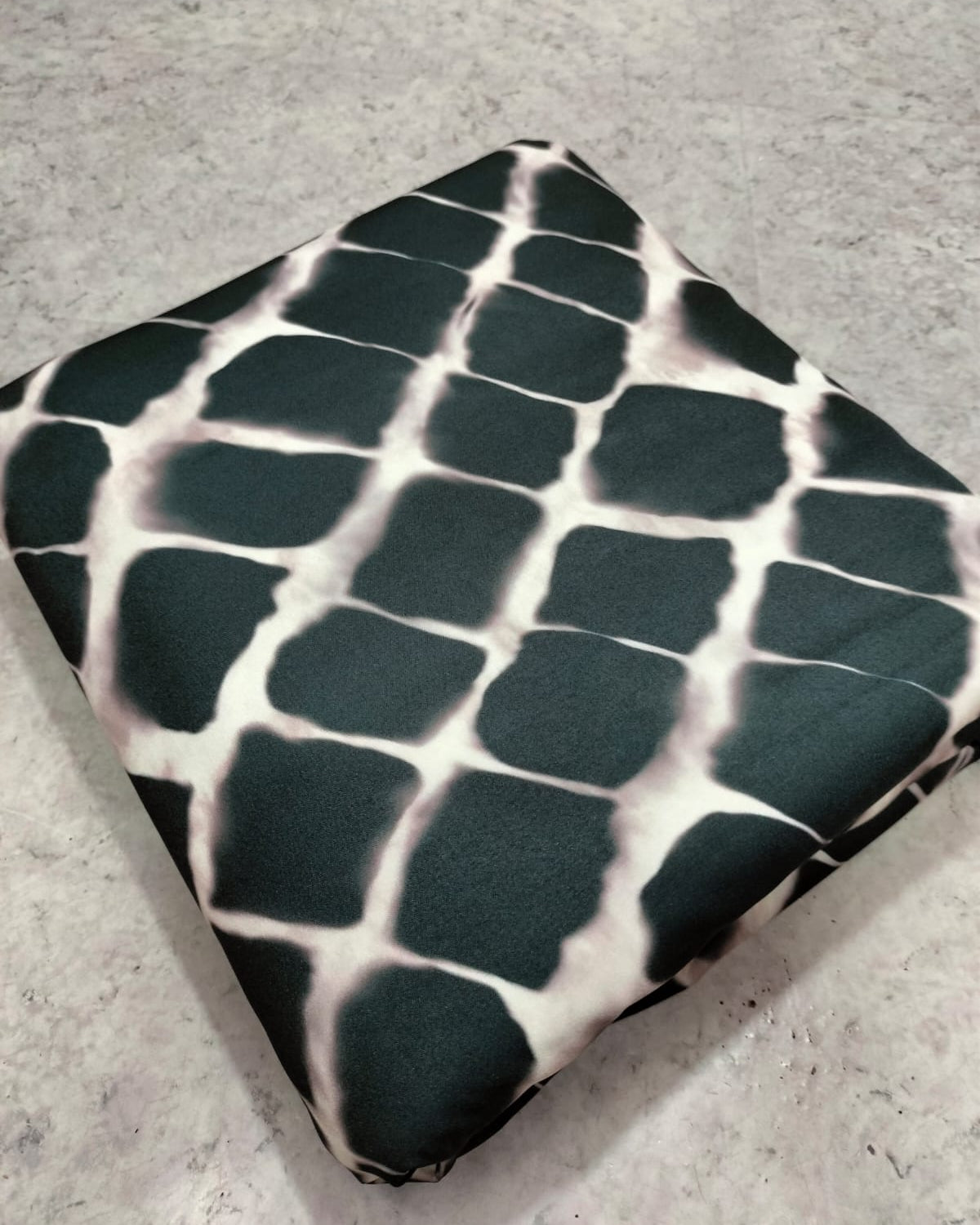 Black and white geometric micro crepe fabric showing drape