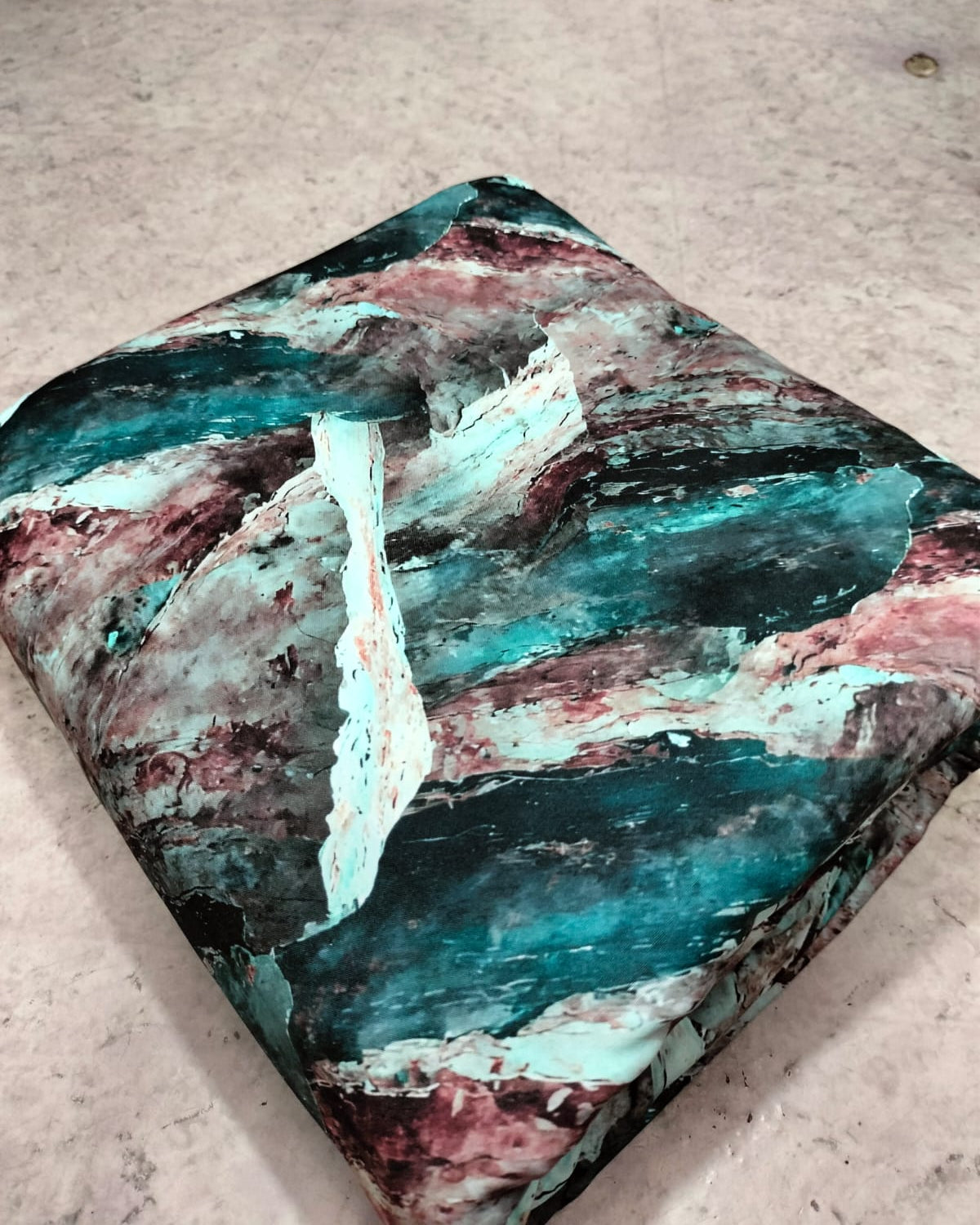Teal and pink abstract micro crepe dress material folded into a cut piece