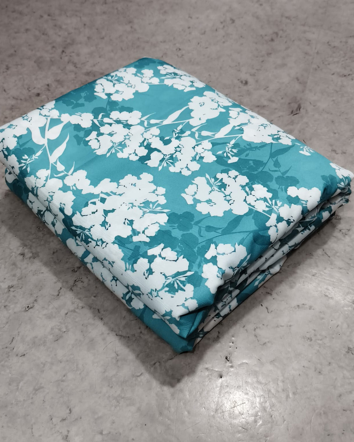 Close detail of the white blossom print on teal micro crepe